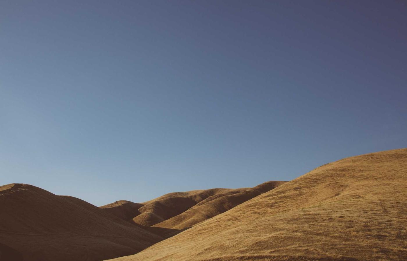 Mujer meditando en un entorno natural al atardecer, simbolizando paz y serenidad.